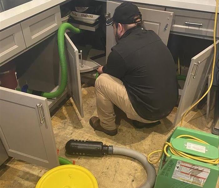 SERVPRO technician doing water damage restoration work in a kitchen