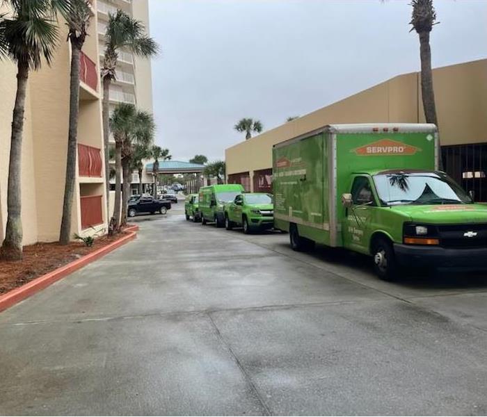 SERVPRO fleet vehicles parked outside a commercial building where they have been deployed for a restoration job
